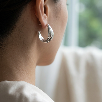 Simple twist metal earrings worn on model ear