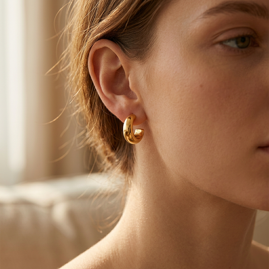 Simple bright C-shaped earrings worn on model ear