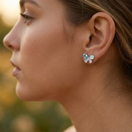 Blue zircon butterfly earrings worn on model ear