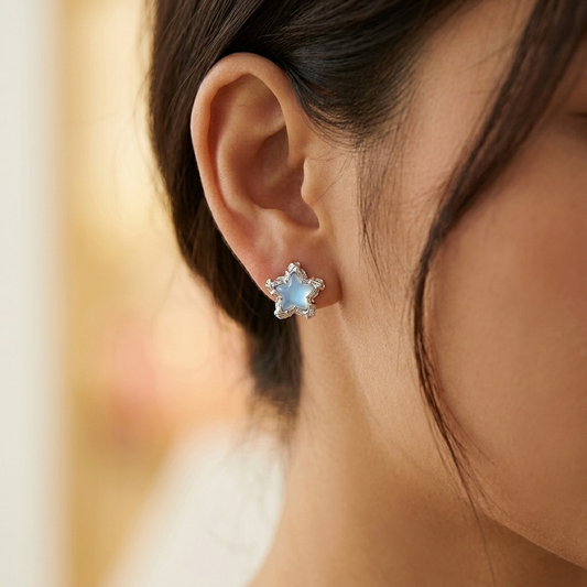 Blue star earrings worn on model ear