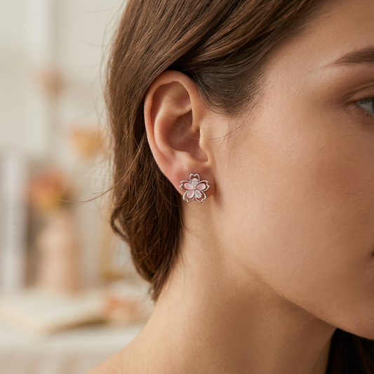Hollow asymmetrical flower earrings worn on model ear