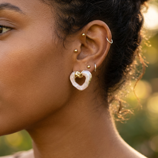 Peach blossom stud earrings worn on model ear